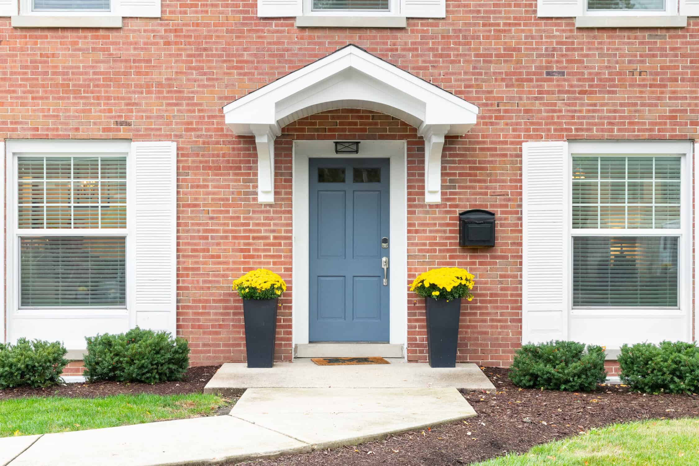 A blue front door on a red brick home.