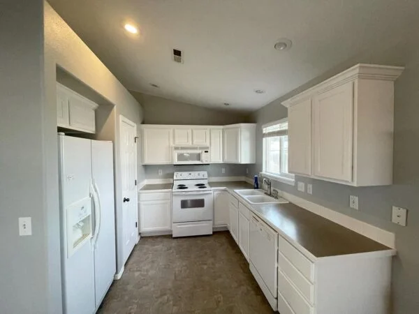 Freshly painted white kitchen cabinets with updated finishes and hardware, cabinet painting by Lagunas Painting in Nampa, Idaho