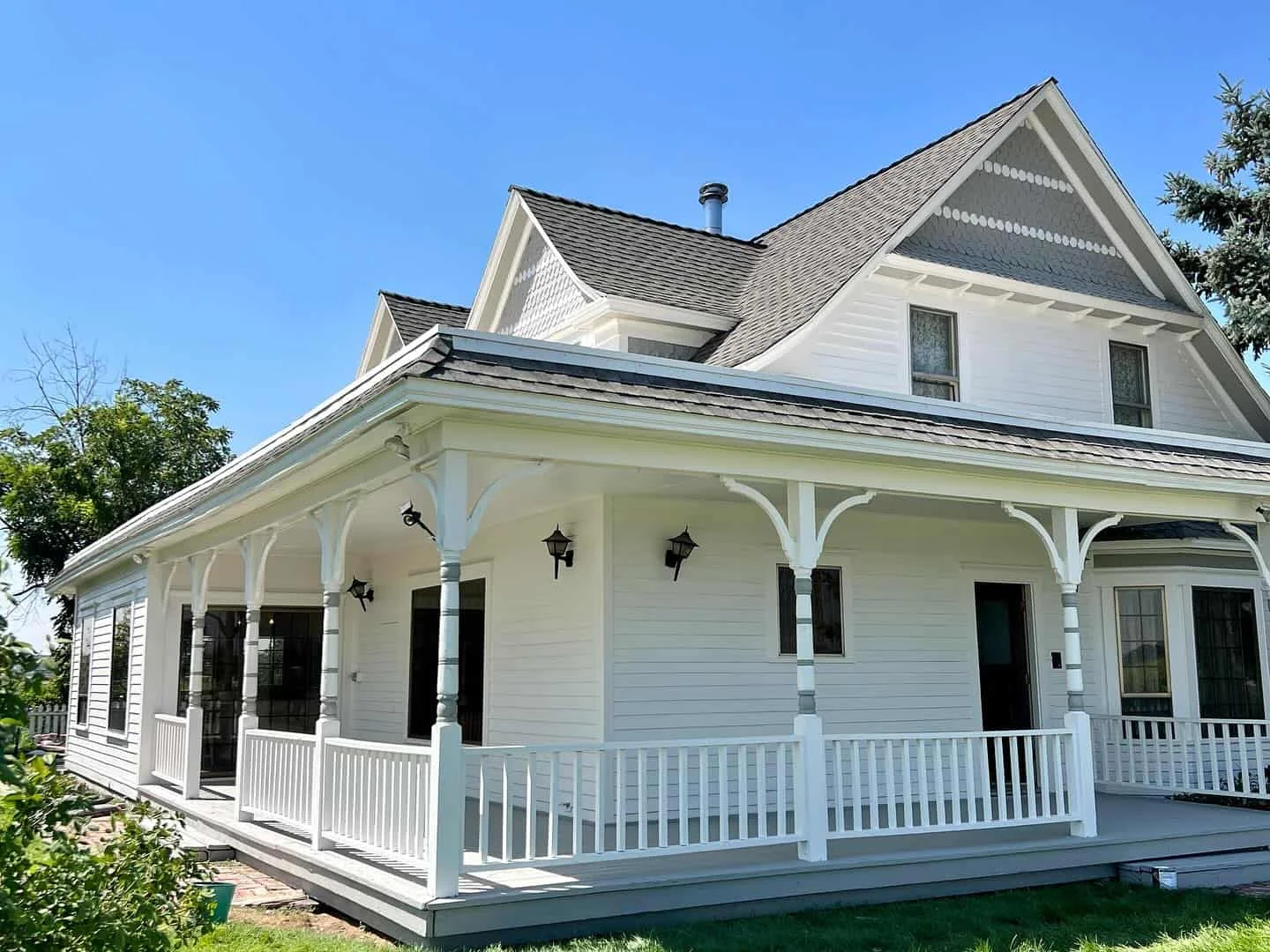 Historic white Victorian home with a wraparound porch and detailed trim in Caldwell, Idaho, exterior house painting by Lagunas Painting