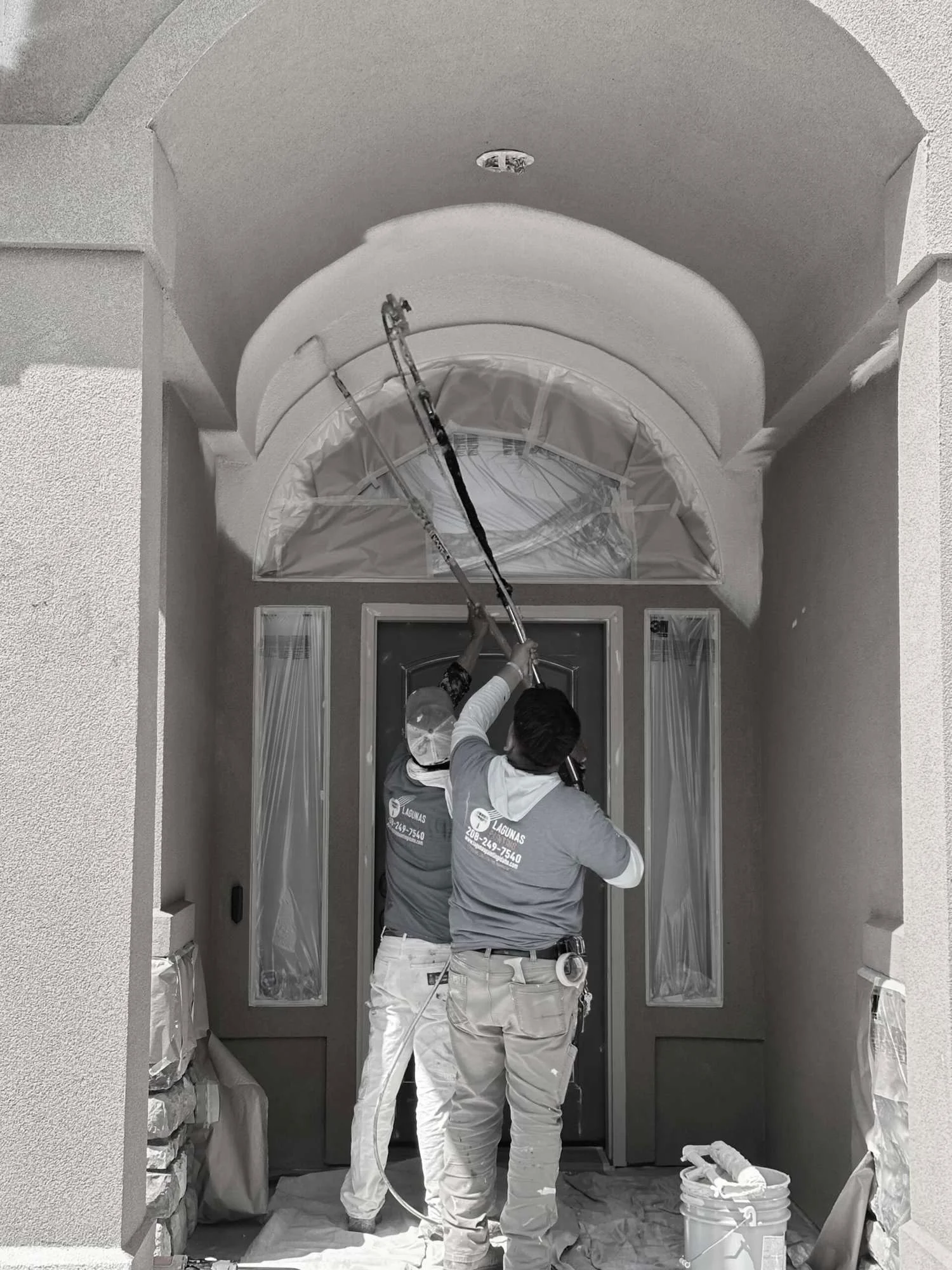 Lagunas Painting team spray painting an exterior home entryway in Caldwell ID