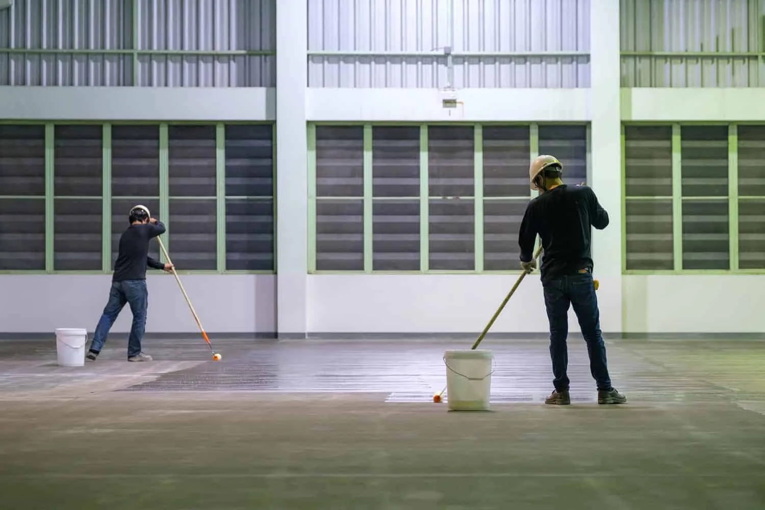 Professional painters applying industrial floor coatings in a large facility by Lagunas Painting in Idaho