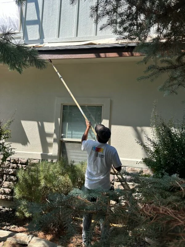 Lagunas Painting professional using an extension pole to paint under the eaves of a home in Boise, Idaho