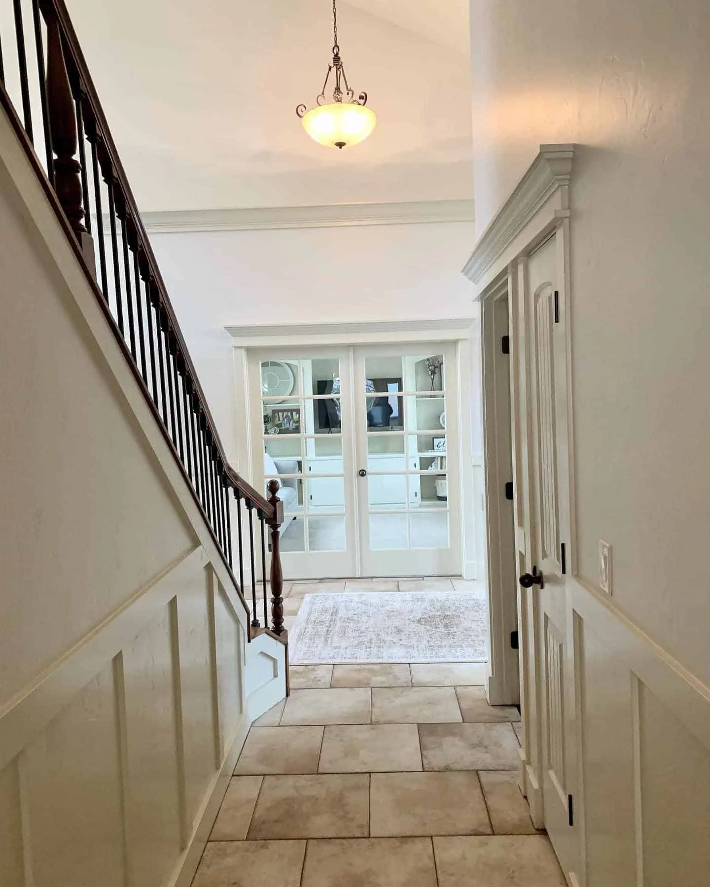 Elegant home interior featuring a detailed staircase and classic french doors with premium white trim paint by Lagunas Painting