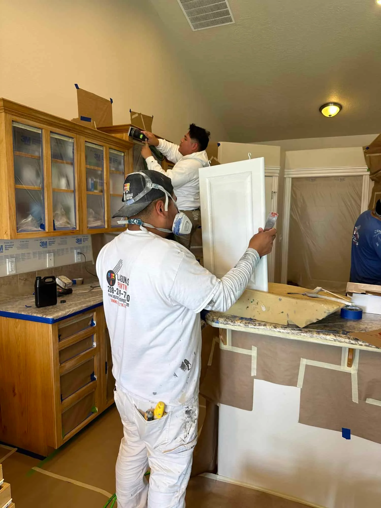 Lagunas Painting team carefully prepping and painting kitchen cabinets in Caldwell, ID