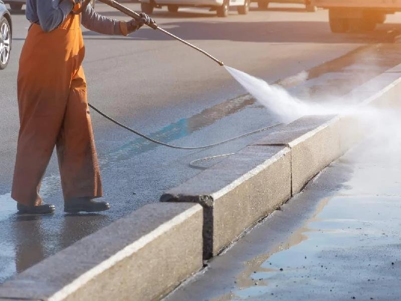 Professional pressure washing service cleaning concrete exterior surface by Lagunas Painting