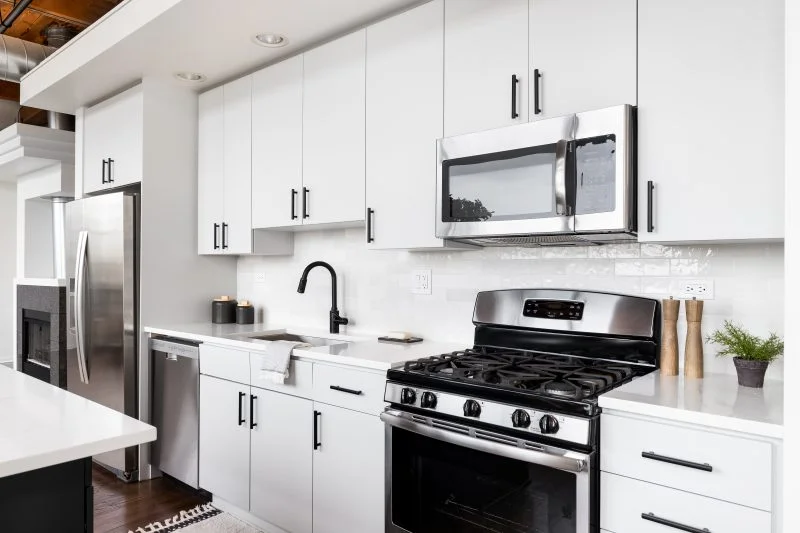 Beautifully refinished cream white kitchen cabinets with warm under-cabinet lighting