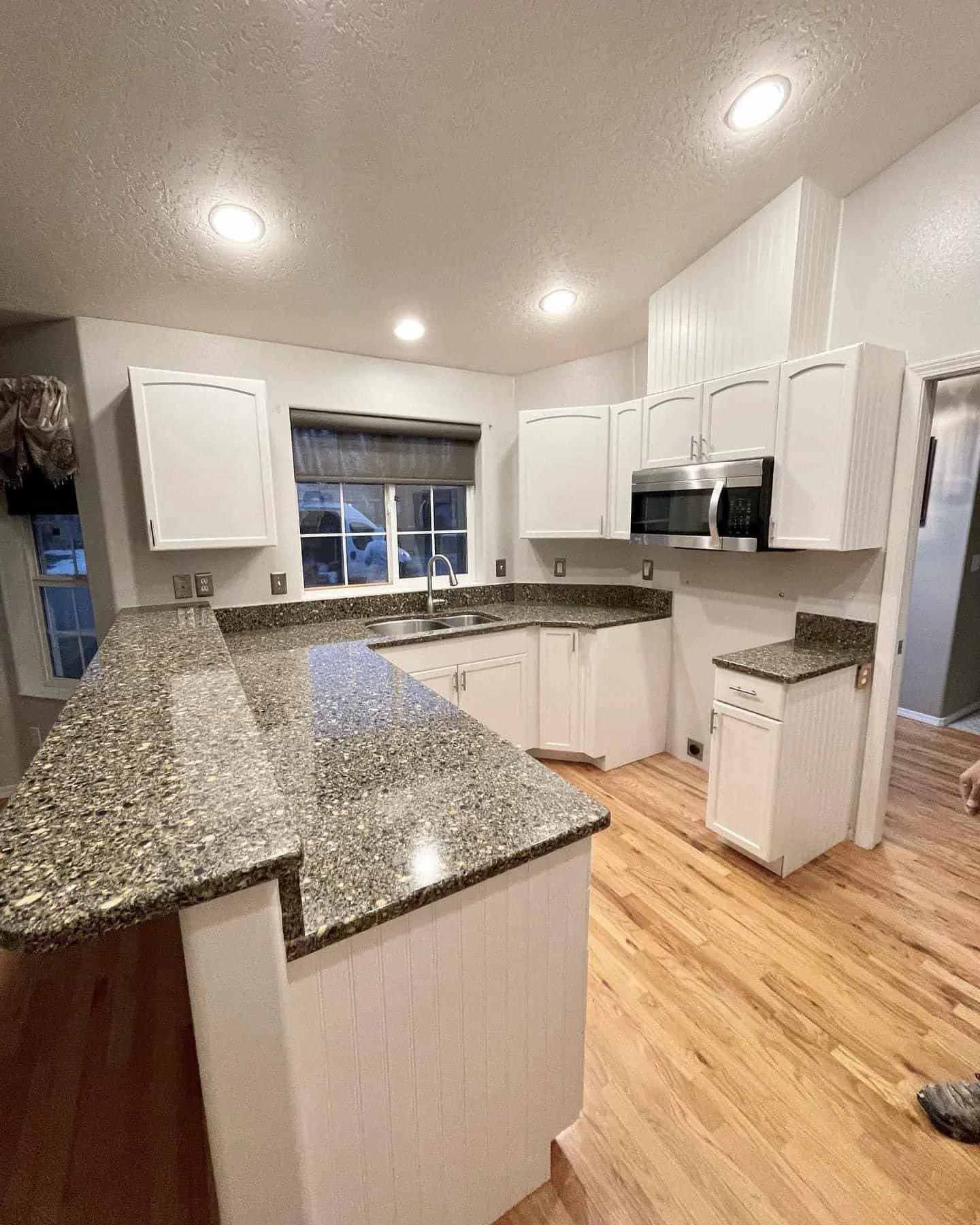 Why Choose Our Cabinet Painters - Freshly painted white kitchen cabinets and granite countertops by Lagunas Painting