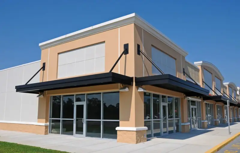 Freshly painted exterior of a modern commercial retail building with awnings and glass storefronts, exterior commercial painting by Lagunas Painting in the Treasure Valley, Idaho