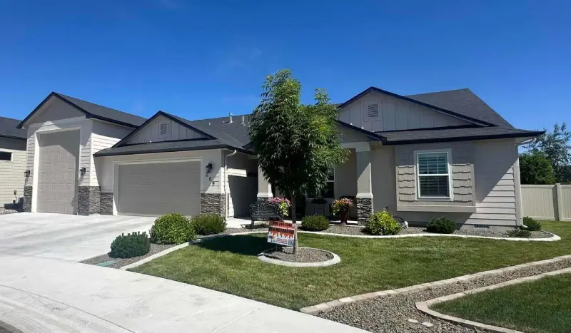 Freshly painted single-story home exterior with a clean driveway and manicured lawn, home painting services by Lagunas Painting in the Treasure Valley, Idaho