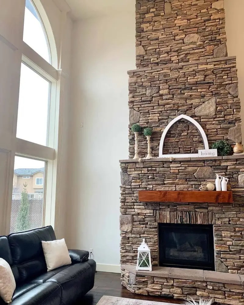 Freshly painted interior with a stacked-stone fireplace and tall arched windows by Lagunas Painting in the Treasure Valley, Idaho