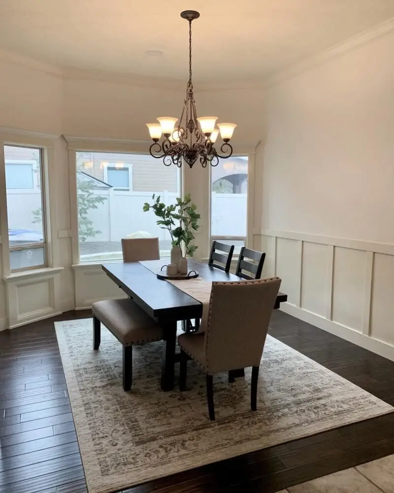 Elegant dining room with a chandelier, dark hardwood floors, and freshly painted walls, completed by Lagunas Painting interior painting contractors in Caldwell, Idaho